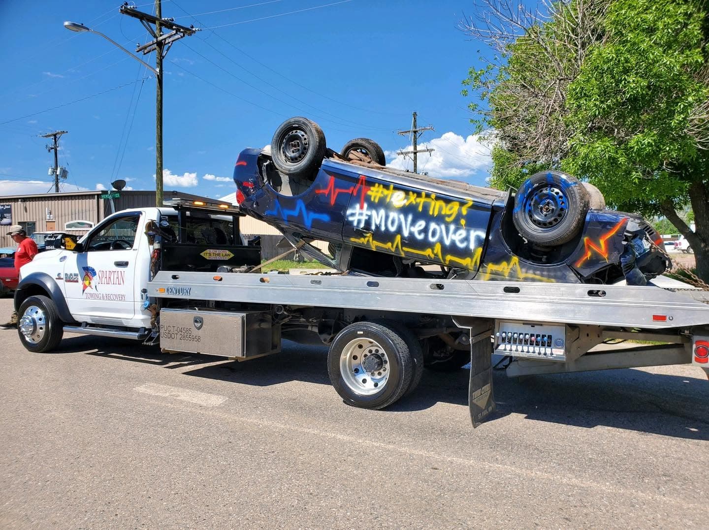 Spartan flatbed carrying a disabled sports car