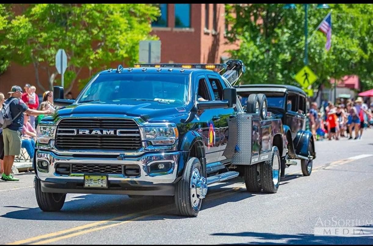 Blue RAM truck with recovery equipment on display at a parade