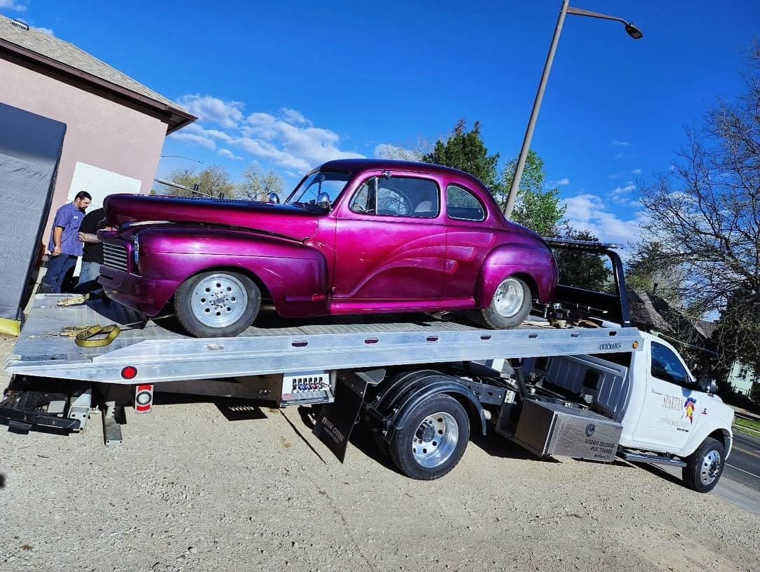 Flatbed loading a hot-pink vintage coupe